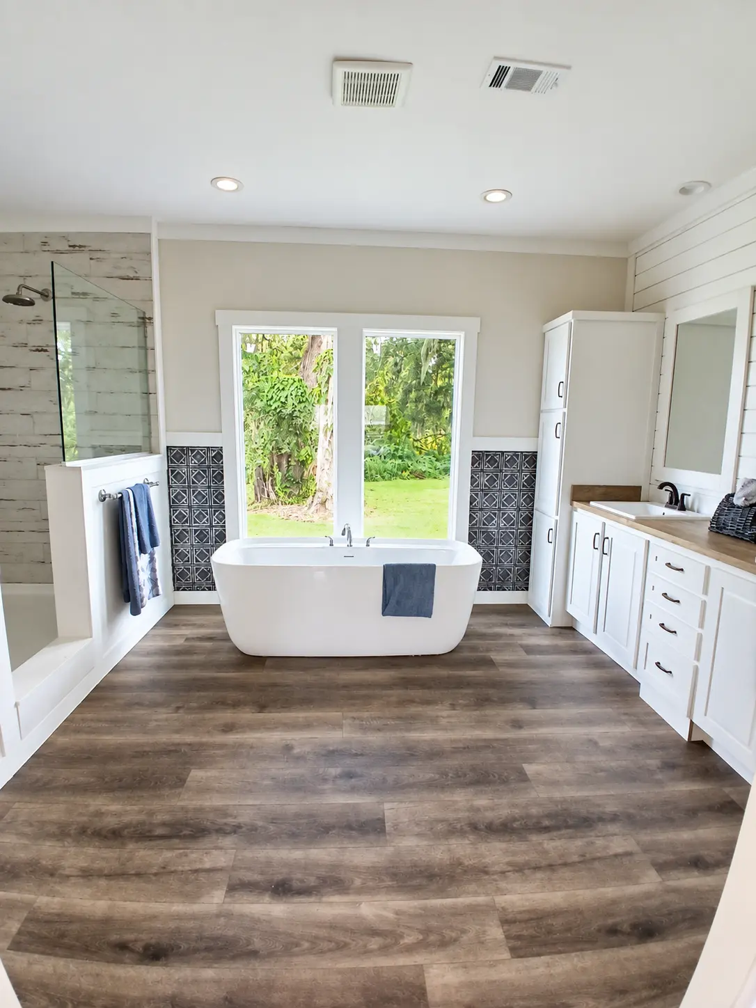 FTK bathroom with freestanding tub, double vanity and wood-look flooring