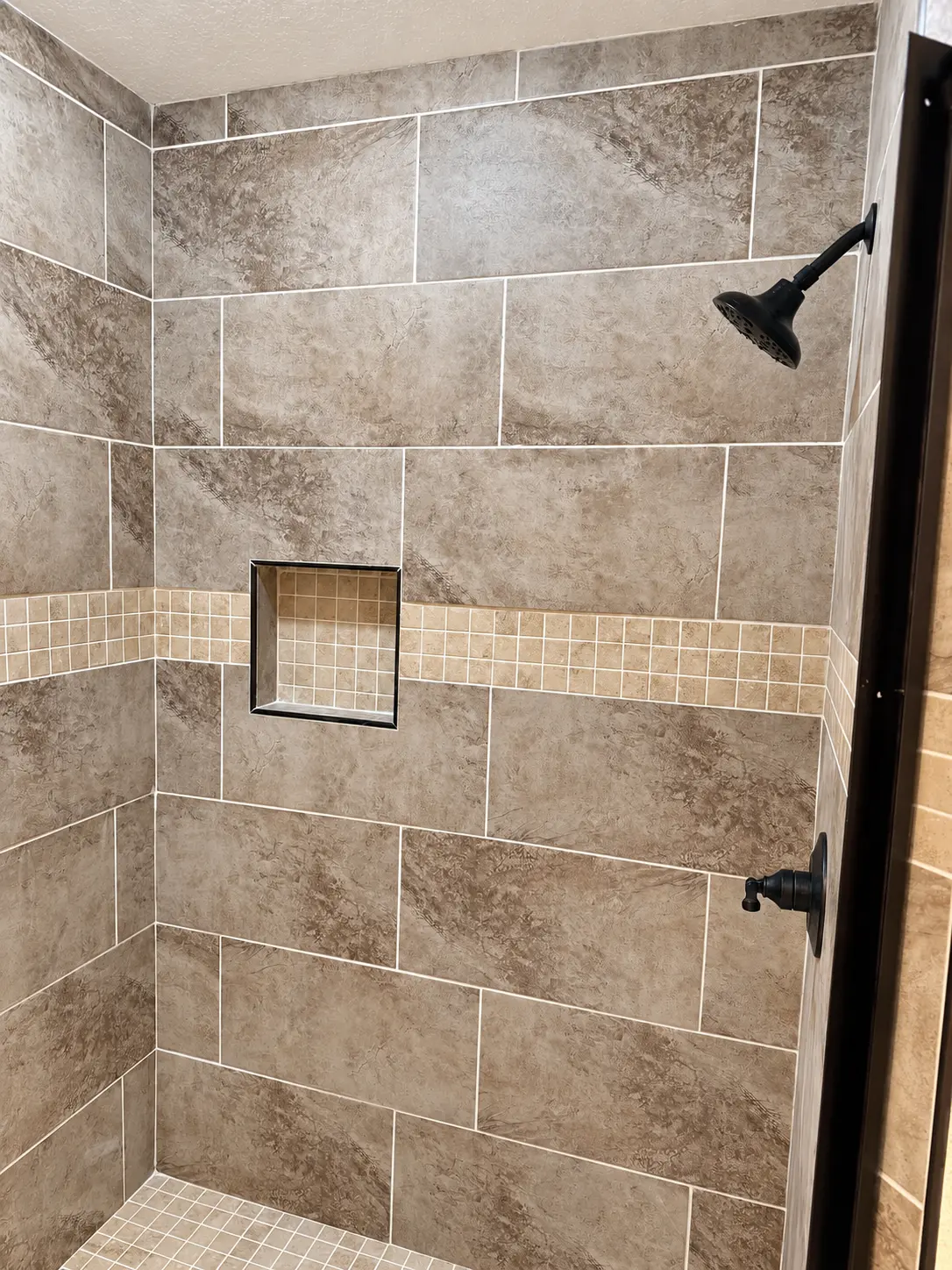 FTK customer shower with stone-look tile, mosaic band and recessed niche